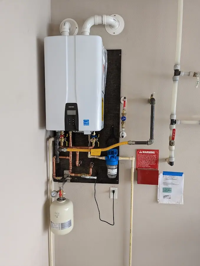 Professional plumber installing copper piping in a West Milford home